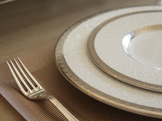 Set of decorative plates with a fork on a brown textured surface