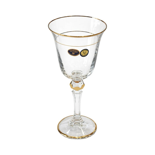 Clear glass with gold rim and base on a white background